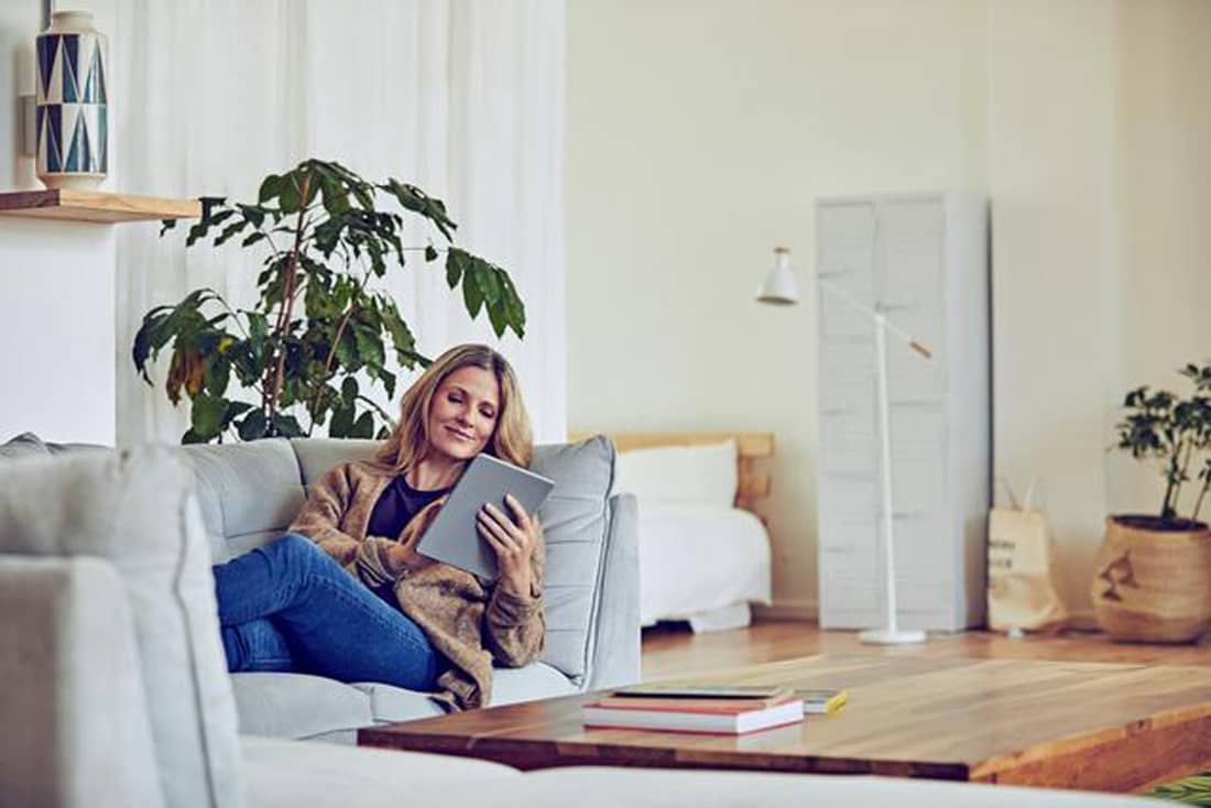 Frau mit Tablet am Sofa